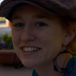 Erin Walker smiles at the camera while wearing a hat.