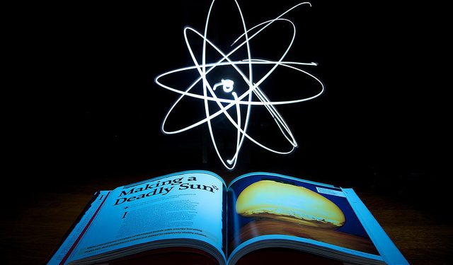 An atom floating over an open book