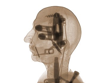 An x-ray picture of a man's head, which is filled with various tools that resemble the interior of a normal head.