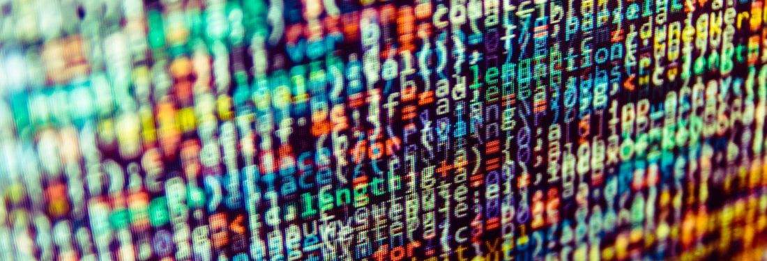 A close up photo of a computer screen with unreadable numbers and words stack on each other and all different colors.