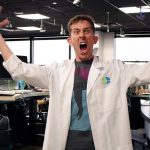 Bob Beard from ASU's Center for Science and the Imagination, in KJZZ's studios, making a roar face and wearing a lab coat.