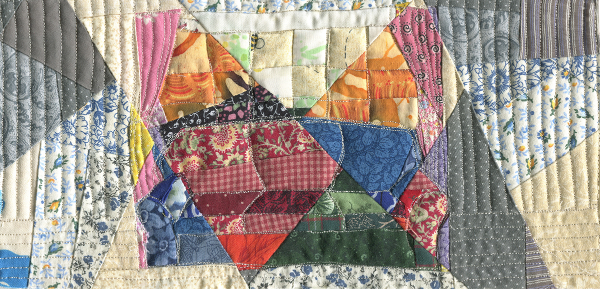 A couch in front of a window, but it is pieced from multiple fabrics and quilted. It is fragmented and multicolored.