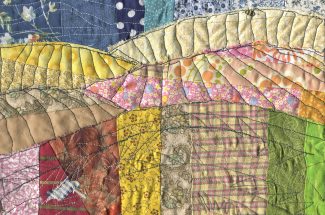 Illustrationdone in fabric, quilted landscape with small person looking over vast hills covered in crops.