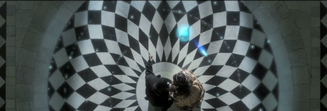A man and woman shot from above, standing on an ornate black-and-white patterned floor with stars and planets swirling around